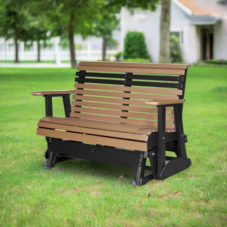 A cedar brown and black colored glider bench in a grassy backyard.