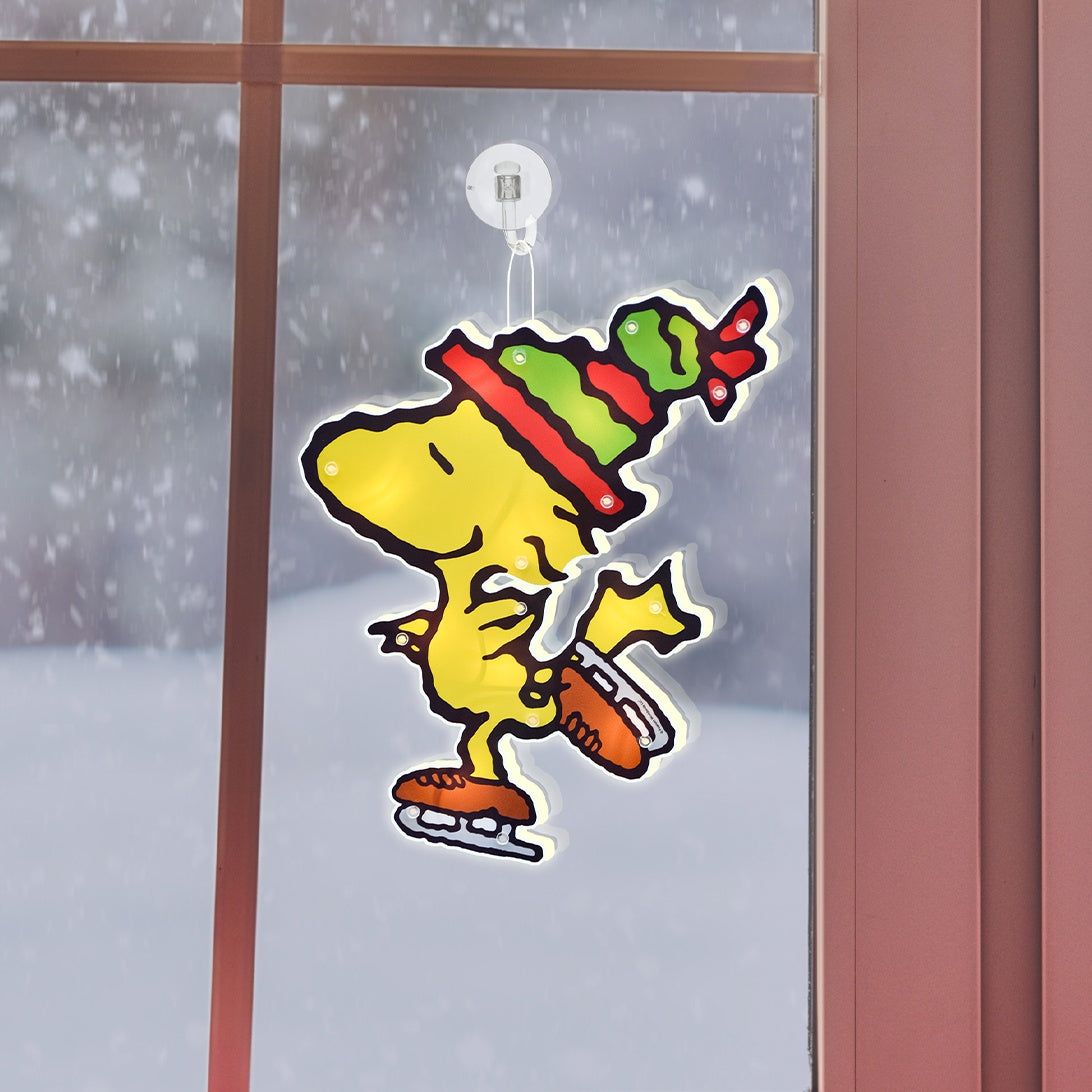 This is a lifestyle image showing the Woodstock decoration hanging in a window.