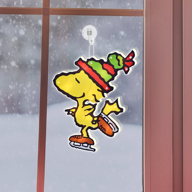 This is a lifestyle image showing the Woodstock decoration hanging in a window.