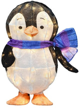 This image shows Wendel the penguin sculpture on a white background. The penguin is black and white with a cute expression on his face. His feet are orange. He's wearing a blue and purple striped scarf. The LED lights inside are turned on.