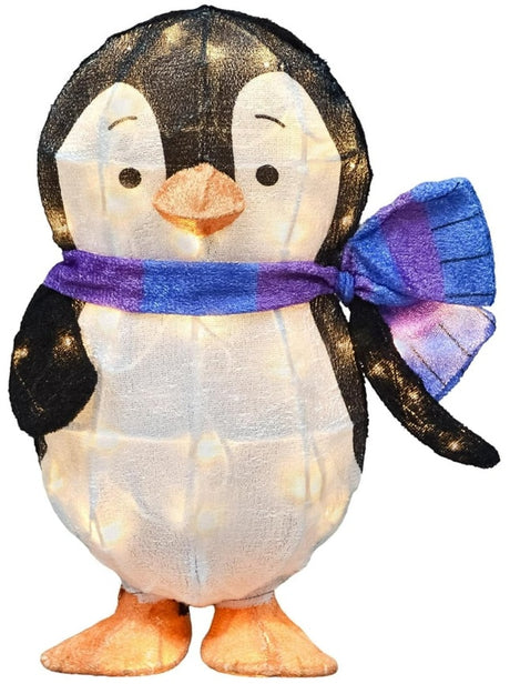 This image shows Wendel the penguin sculpture on a white background. The penguin is black and white with a cute expression on his face. His feet are orange. He's wearing a blue and purple striped scarf. The LED lights inside are turned on.