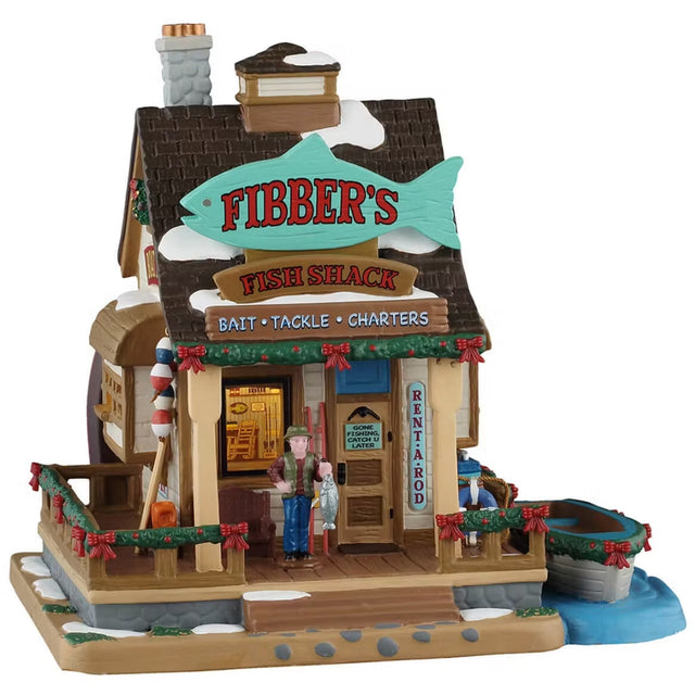 This is a Lemax lighted building designed to look like a small fish shack. There's snow on the roof and on the sidewalk. There are signs that read "FIBBER'S FISH SHACK. BAIT. TACKLE. CHARTERS" and "RENT A ROD." A man stands on the deck holding a fish.