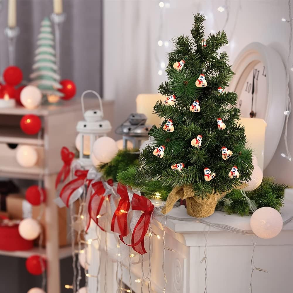 This is a lifestyle image showing a small tabletop tree in a room decorated for Christmas. There are Bumble lights on the tree.