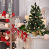 This is a lifestyle image showing a small tabletop tree on a mantel in a room decorated for Christmas. There are Rudolph lights on the tree.