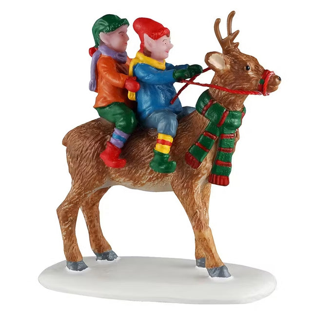 This is a Lemax figurine designed to look like two elves riding on the back of a reindeer. The reindeer is wearing a red and green striped scarf.