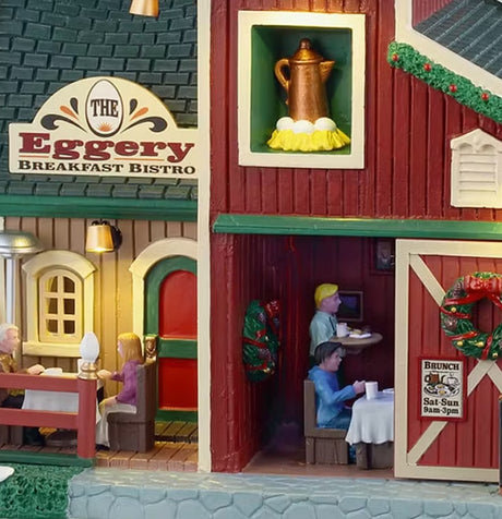 This is an up close view of the building. There's a sign above the front door that reads "THE EGGERY BREAKFAST BISTRO." There's also a sign on the sliding door that reads "BRUNCH: SAT & SUN 9 am to 3 pm."