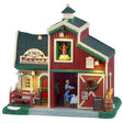 This is a Lemax lighted building designed to look like a barn turned into a breakfast restaurant. There are decorated garlands along the roof and a decorated wreath on the sliding barn door. There's a couple eating at a table on the balcony. Inside the building, there's a waiter bringing a table of people their breakfast. There's some snow on the grass.