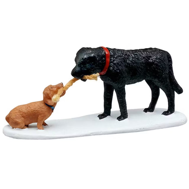 This is a Lemax figurine designed to look like a small brown dog and a large black dog playing tug-of-war with a rope.