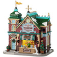 This is a Lemax lighted building designed to look like a red brick store. There's a sign over the front door that reads "MADE FRESH DAILY." There's a wreath on the front door and two potted trees. There's a booth in the front you can walk up to and order candy from the person at the register. There's a white dog peeking over.