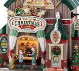 This is an up close view of the building. There are signs that read "Free Samples Today" and "Baked Fresh Daily" and "Open Come On In!"
