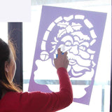 This image shows a person putting a Santa stencil on a window and spraying the artificial snow in it.
