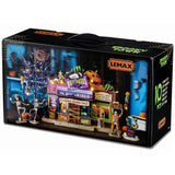 This is the box that this Lemax House Set comes in. It's showing off: four figurines, one spooky tree, two lampposts, one lighted building and two adaptors.
