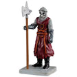 This is a Lemax Spooky Town figurine designed to look like a skeleton wearing armor and a royal red colored uniform. He's holding a tall war hammer.