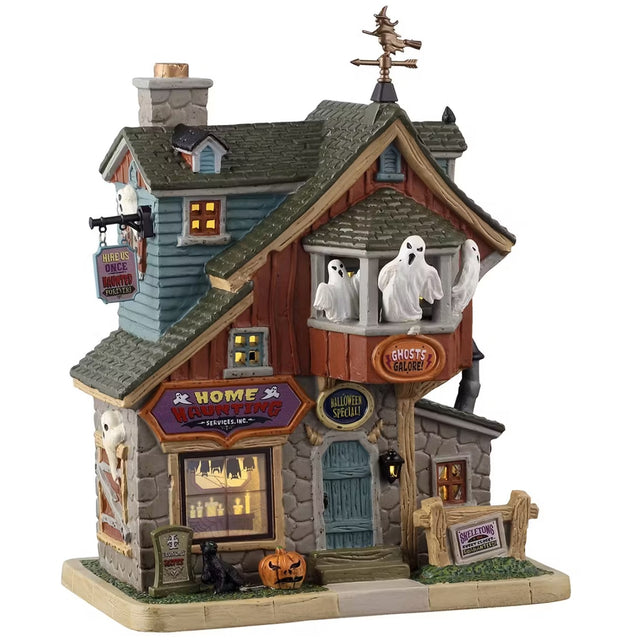 This is a Lemax Spooky Town lighted building designed to look like a tall, rustic house. There's a sign hanging off the side that reads "Hire us once, haunted forever." There's a room on the second floor that has windows open and you can see three ghosts flying around inside. Inside the window, you can see a bunch of lit candles. Outside the window, there's a tombstone, a black cat and a jack-o-lantern.