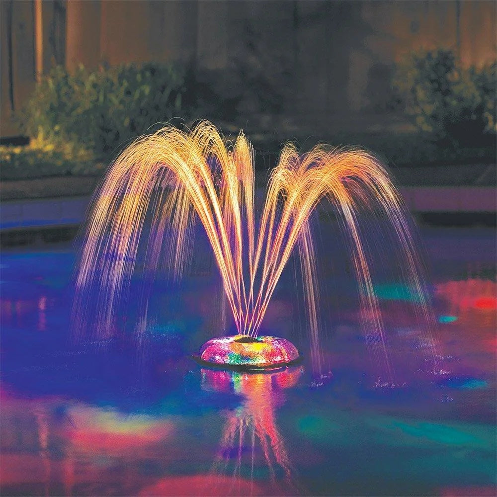 This is a lifestyle image showing a pool fountain light show in the middle of a pool.