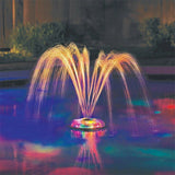 This is a lifestyle image showing a pool fountain light show in the middle of a pool.