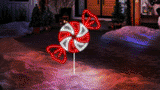 This moving image shows the peppermint candy LED light on a stake in front of a house on a snowy night.