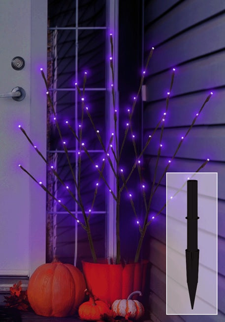 This is a lifestyle image showing the three branches inside of an orange flower pot on a porch near a front door. There's also a picture of one of the black ground stakes so you can see what they look like.