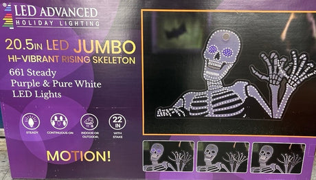 This image shows the box that the skeleton decoration comes in. It reads "20.5 in. LED Jumbo Hi-Vibrant Rising Skeleton. 661 Steady Purple & Pure White LED Lights. Continuous-On lights. Indoor/Outdoor use. 22 in. with stake."
