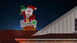 This animated image shows the Santa decoration on top of a roof.