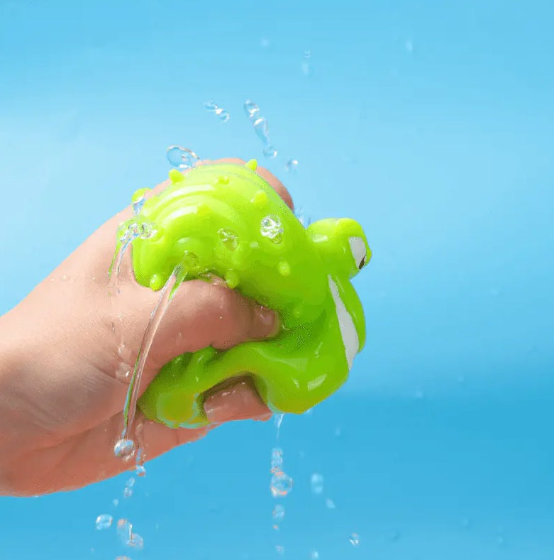 This image shows a hand squeezing the water out of the green snail ball.