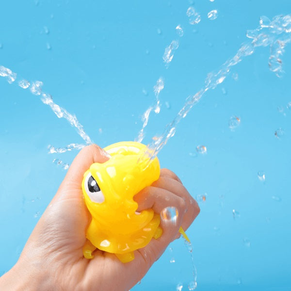 This image shows a hand squeezing the water out of the yellow squid ball.