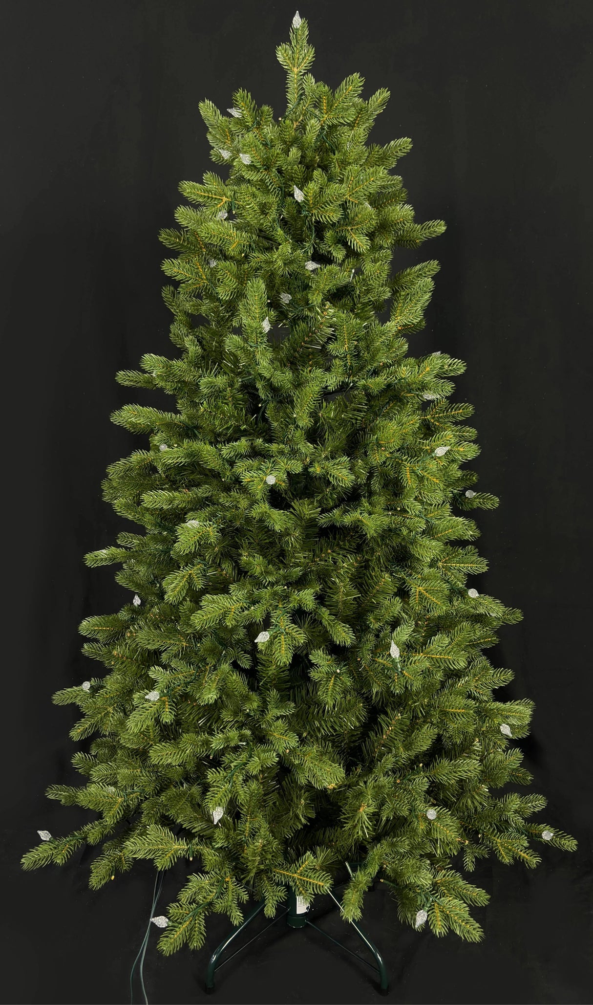 This image shows this specific artificial tree with the lights turned off. This tree is up against a black background.