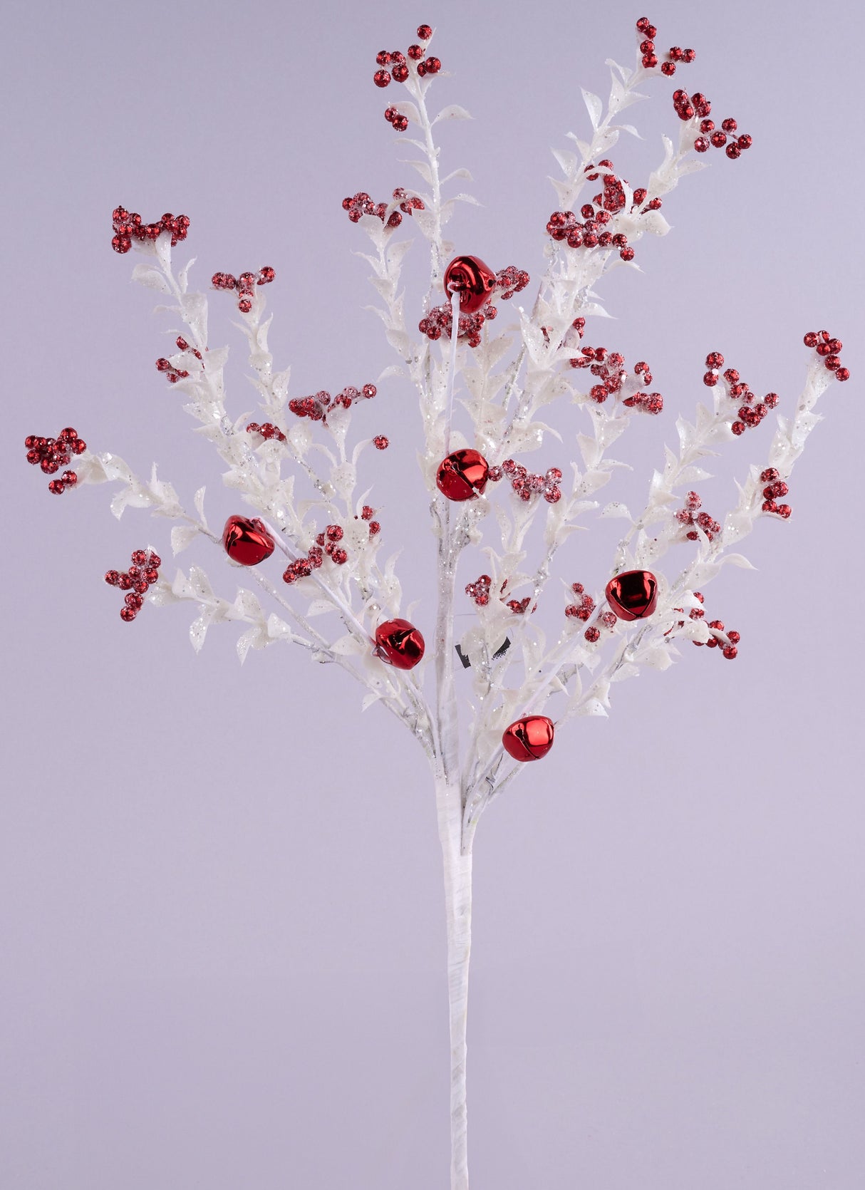 This image shows this pick spray up against a light purple background. The pick is a white stem with glittered white branches with small glitter leaves on them. Some of the branches are decorated with red jingle bells, in both small and large sizes.