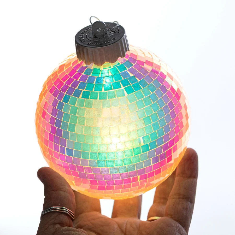 This image shows someone holding the mirror ball ornament with the lights on inside.