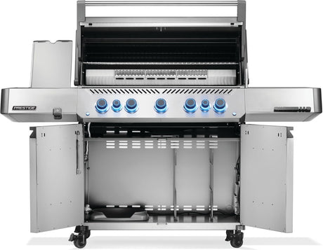 Silver and gray Napoleon grill. There is a built-in thermometer on the lid, there are two shelves outstretched, seven buttons and a cabinet that opens up underneath. This is the view of everything open.