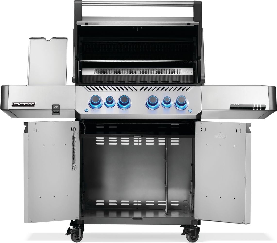Silver and gray Napoleon grill. There is a built-in thermometer on the lid, there are two shelves outstretched, six buttons and a cabinet that opens up underneath. This is the view of everything open.