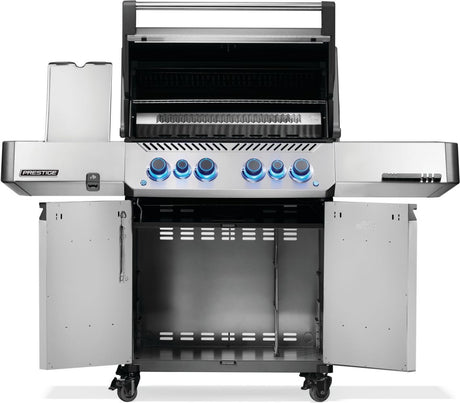 Silver and gray Napoleon grill. There is a built-in thermometer on the lid, there are two shelves outstretched, six buttons and a cabinet that opens up underneath. This is the view of everything open.