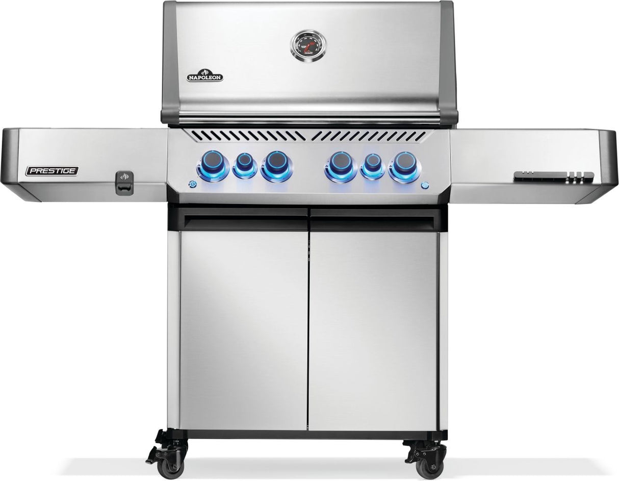 Silver and gray Napoleon grill. There is a built-in thermometer on the lid, there are two shelves outstretched, six buttons and a cabinet that opens up underneath. This is the front view.