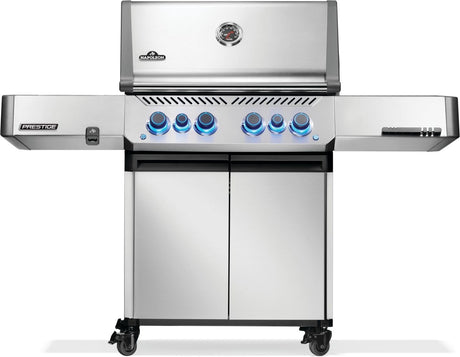 Silver and gray Napoleon grill. There is a built-in thermometer on the lid, there are two shelves outstretched, six buttons and a cabinet that opens up underneath. This is the front view.