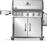 Silver and gray Napoleon grill. There is a built-in thermometer on the lid, there are two shelves outstretched, six buttons and a cabinet that opens up underneath. This is the front view with one shelf down.