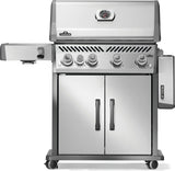 Silver and gray Napoleon grill. There is a built-in thermometer on the lid, there are two shelves outstretched, five buttons and a cabinet that opens up underneath. This is the front view with one shelf down.