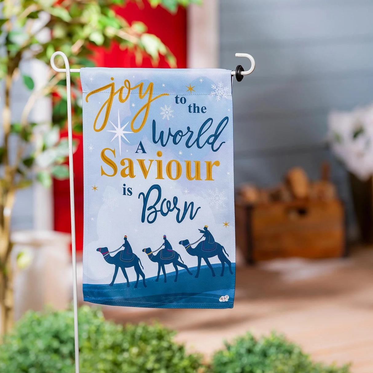A flag with a design on the front that reads "Silent night, holy night, all is calm, all is bright" in a mixture of cursive and normal printing. The design on the back reads "Joy to the world, a savior is born" in a mixture of cursive and normal printing.