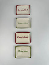 Decorative stoneware dish. One dish reads "Tis the Season" and has a green border. One dish reads "Merry & Bright" and has a red border. One dish reads "Peace on Earth" and has a green border. One dish reads "Joy to the World" and has a red border.