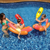 An inflatable ride on pool game. The pool floats are shaped like hot dogs in buns. The battle boppers are shaped like condiments. One is ketchup and one is mustard. This image shows children on the hot dogs battling in the pool while their mom watches.