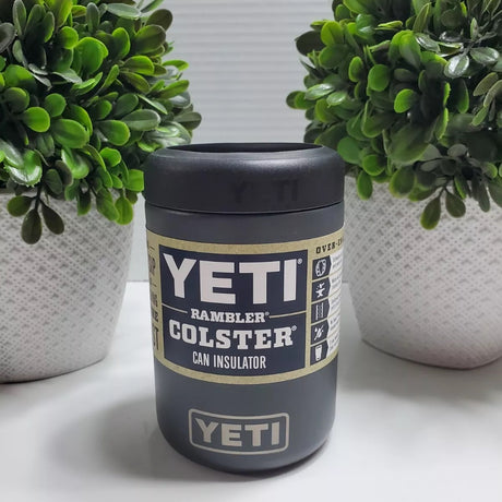 Charcoal colored Yeti colster on a table between two succulents.
