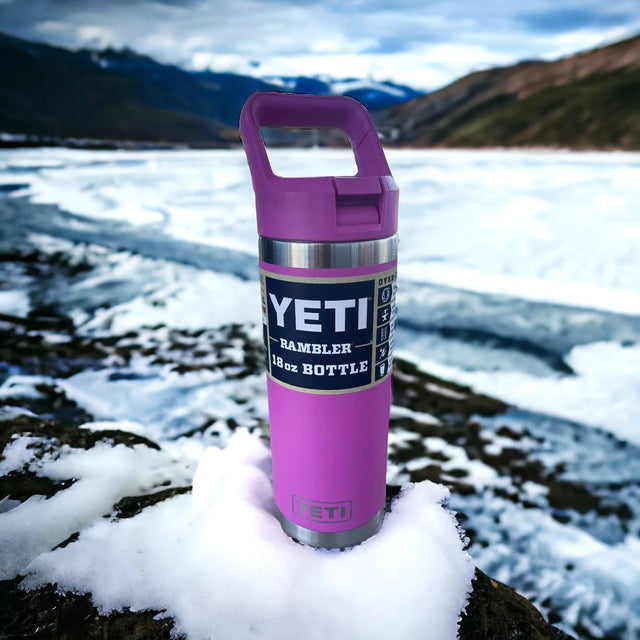 Fuchsia colored 18 oz. YETI water bottle. This lifestyle image shows it in the snow with a mountain in the background.