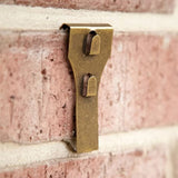 This is a lifestyle image showing one of the clips resting on a brick.
