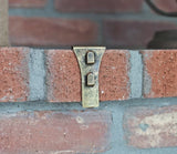 This is a lifestyle image showing one of the clips resting on a brick.