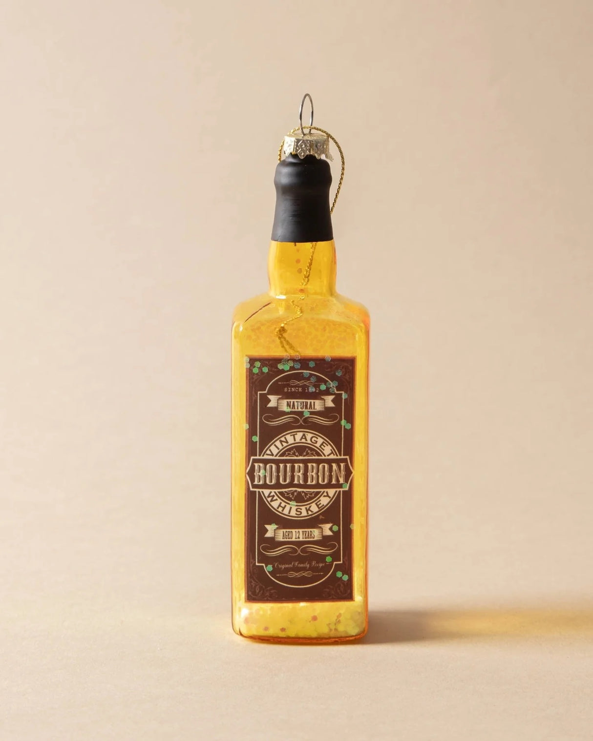 Ornament shaped like a miniature bottle of alcohol. One ornament is red and reads "Aged Brandy." One ornament is yellow and reads "Whiskey." One ornament is orange and reads "Scotch." One ornament is yellow and reads "Bourbon." One ornament is light blue and reads "Gin." Each ornament has glitter inside.