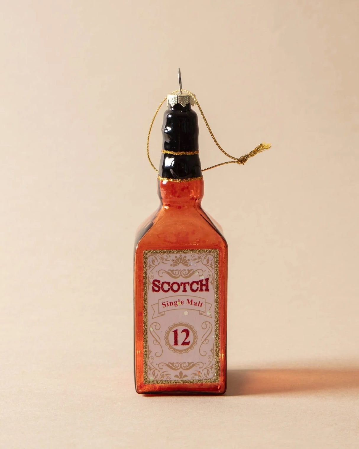 Ornament shaped like a miniature bottle of alcohol. One ornament is red and reads "Aged Brandy." One ornament is yellow and reads "Whiskey." One ornament is orange and reads "Scotch." One ornament is yellow and reads "Bourbon." One ornament is light blue and reads "Gin." Each ornament has glitter inside.