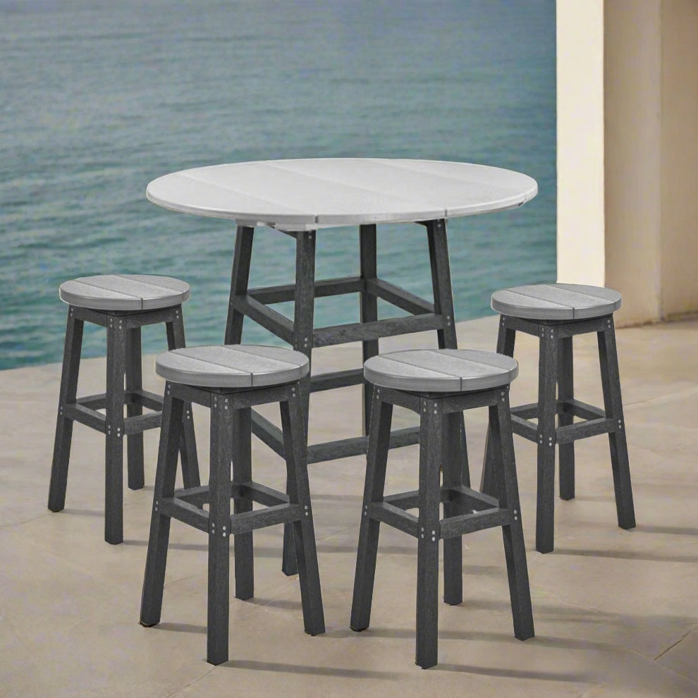 A two-tone light gray and dark gray counter height pub table with four backless stools on a balcony overlooking a body of water