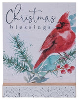 This image shows a male cardinal on a pine branch decorated with berries. It reads "Christmas Blessings."