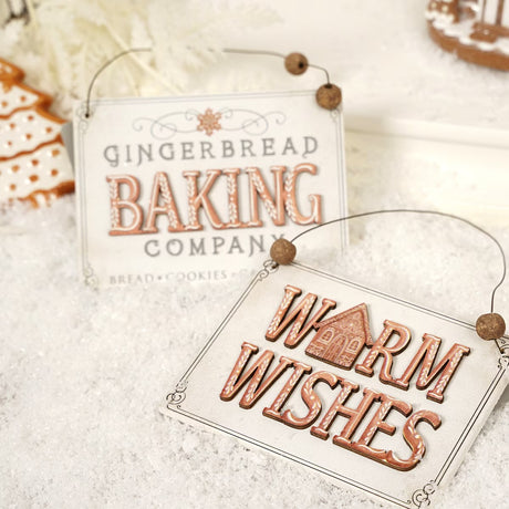 Ornament shaped like a holiday sign. One sign reads "Warm Wishes." One sign reads "Gingerbread Baking Company. Bread, Cookies, Cakes, Pies." Each sign has a dainty border and small wooden beads on the wire holder.