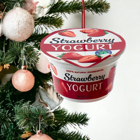 Ornament shaped like a cup of yogurt. One ornament is white and red and "flavored" strawberry. One ornament is white and blue and "flavored" blueberry. One ornament is white and orange and "flavored" peach. One ornament is white and blue and "flavored" Greek-style.