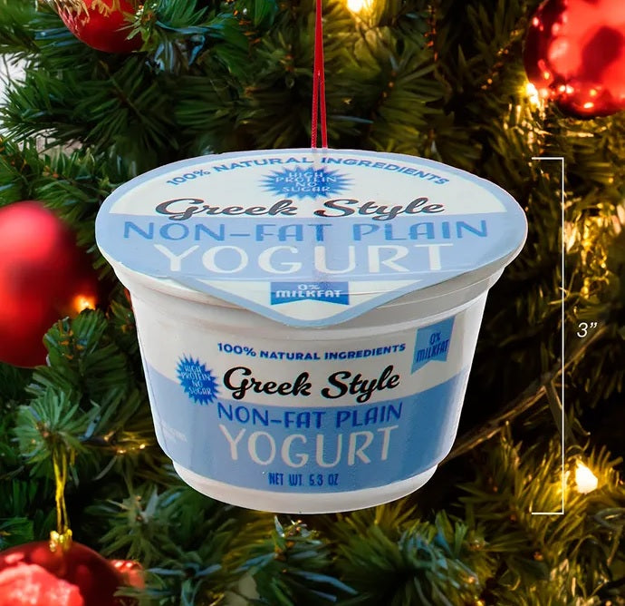 Ornament shaped like a cup of yogurt. One ornament is white and red and "flavored" strawberry. One ornament is white and blue and "flavored" blueberry. One ornament is white and orange and "flavored" peach. One ornament is white and blue and "flavored" Greek-style.